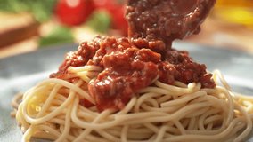 Pouring Tomato Sauce with Ground Beef onto the `Pasta Dish - Spaghetti Bolognese Served on a Bright Plate, Dolly out, Slow Motion - Powered by Shutterstock - Get 15% off with code: PIKWIZARD15