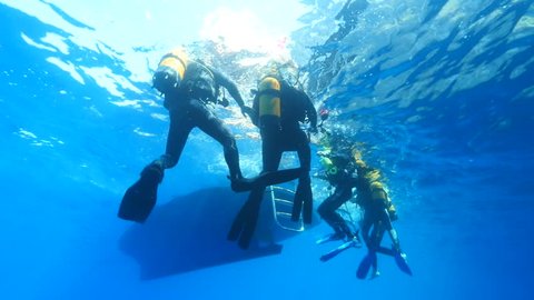scuba divers waiting to get on the boat underwater end of dive ocean scenery