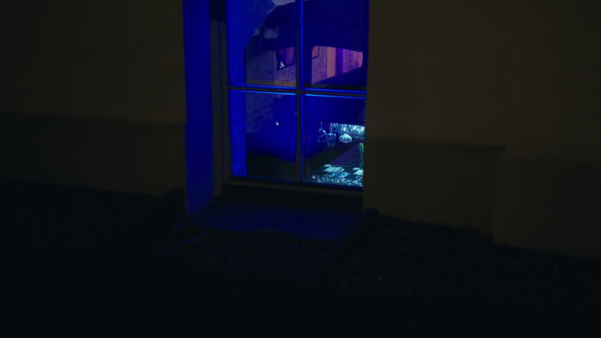 Violet light illuminates a glass rectangle in the dark room