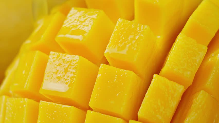 Slow Motion Shot of Mango Juice Splashing through Mango Cube Slices Royalty-Free Stock Footage #3480662219