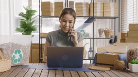 Asian SME owner go green net zero waste retail store shop busy talk mobile phone call eco packaging box design. Asia people young adult woman happy work at home office desk smart vendor seller order. - Powered by Shutterstock - Get 15% off with code: PIKWIZARD15