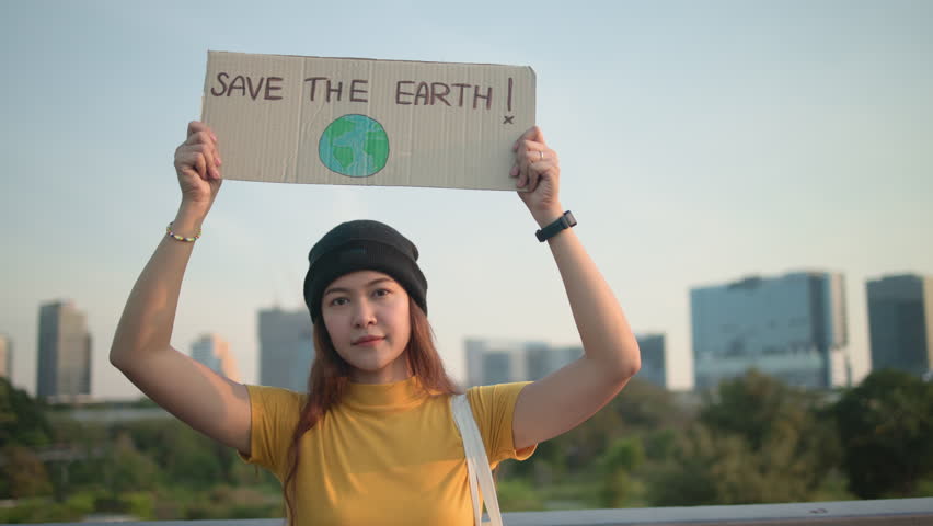 Go green Gen Z woman asia young people looking at camera stress showing save the earth planet world care banner poster sign in city nature tree. Protect global warming future asian hope net zero waste Royalty-Free Stock Footage #3480672521
