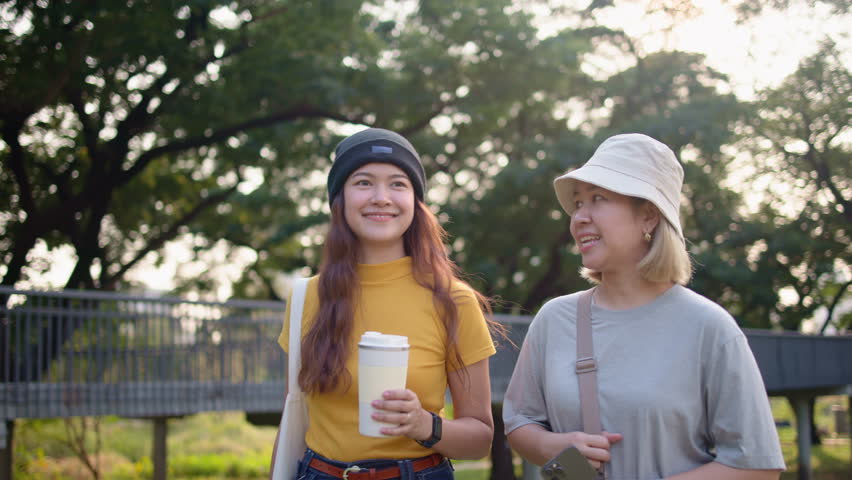 Go green two asia people happy woman talk walk fun in city life sun light tree public park. Future asian hope the way forward save the earth net zero waste reduce issues by reuse bottle eco tote bag. Royalty-Free Stock Footage #3480675567