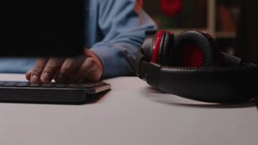 Tilting up shot of Biracial teenage boy wearing headset with mic and starting playing online game on pc sitting in gaming chair at neon light room - Powered by Shutterstock - Get 15% off with code: PIKWIZARD15