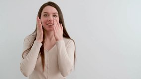 admiration surprise young woman covers face with hands to cover mouth smiling blinks eyes in studio advertising joy feeling of happiness sale good prices 