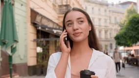 Young caucasian european woman talking chat mobile phone cellphone city outside cheerful happy girl smiling drinking holding cup coffee cafe businesswoman urban gen z street call discuss friendly talk - Powered by Shutterstock - Get 15% off with code: PIKWIZARD15