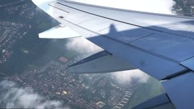 View through an airplane window. Airplane window view showing wing of a plane flying over Germany. Aerial footage. Travel concept.