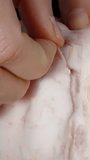 Vertical video. Close-up of female hands peeling the thick skin off the pomelo flesh.