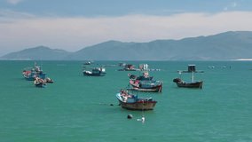 Vietnamese coastline looking out over the south china sea in Nha Trang Vietnam with a turquoise ocean and fishing boats high definition time lapse movie footage.