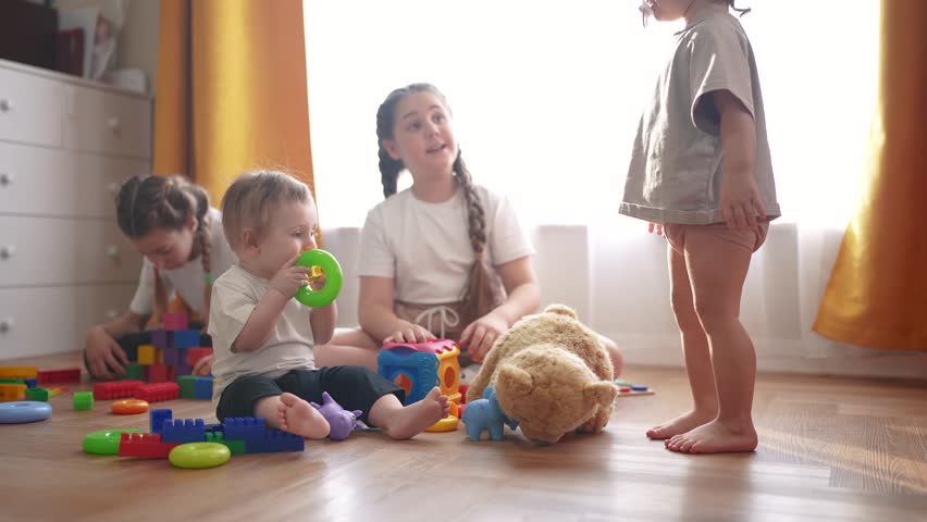 baby group children playing toys on floor indoors. happy family kindergarten kid dream concept. lifestyle group children playing in kindergarten indoors toddlers and babies and kids into toys Royalty-Free Stock Footage #3481001407