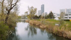 4K video of a park near Alte Donau lake in Austria with Vienna city's skyline in the background.
