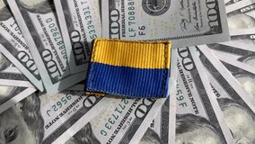 American dollar bills on fabric with the texture of Ukrainian military pixel camouflage. Fabric with a camouflage pattern of grey, brown and green pixels. Close-up of the official uniform of Ukrainian - Powered by Shutterstock - Get 15% off with code: PIKWIZARD15