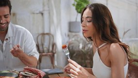 Laughing woman eating dinner at open air cafeteria closeup. Cheerful wife talking with husband sharing tasty meal together. Positive couple enjoying vegan food communicating at patio. Weekend life - Powered by Shutterstock - Get 15% off with code: PIKWIZARD15