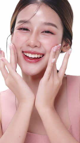 Vertical footage beautiful young Asian woman with healthy facial skin isolated over white background for skincare commercial product advertising. Slow motion shot.
