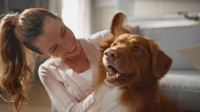 Girl scratching lovely dog behind ears sitting home floor together close up. Smiling woman caressing adorable happy pet enjoying fluffy wool. Cheerful canine owner expressing love to adorable animal. - Powered by Shutterstock - Get 15% off with code: PIKWIZARD15