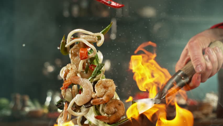 Super slow motion of flying asian wok noodles with prans and vegetable. Filmed on high speed cinema camera, 1000 fps. Speed ramp effect.