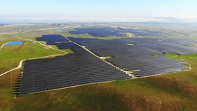 Aerial 4k video of photovoltaic solar power plant in motion, sweeping the image
