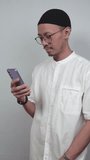 Asian Muslim men show joy when video calling with family in their hometown. The concept of celebrating Eid long distance