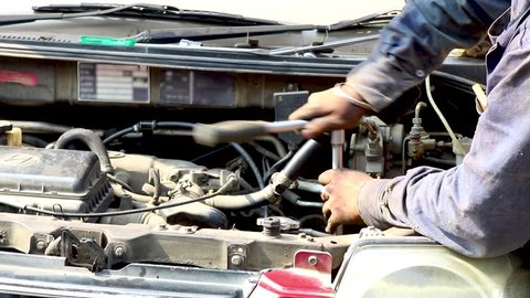 auto mechanic tighten screw with spanner during automobile car maintenance at engine repair service station india