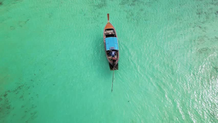 A row of watercraft lined up in a circle on the liquid surface, creating an artful display for a recreational event. The blue boats serve as fashionable accessories for travel enthusiasts