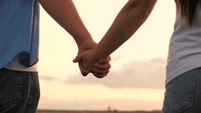 Couple man and woman taking hands to each other at sunset sky summer meadow romantic date closeup. Enamored male and female holding arms together with love tenderness best feelings outdoor back view - Powered by Shutterstock - Get 15% off with code: PIKWIZARD15
