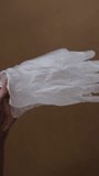 Female hands wear transparent protective gloves. Vertical video.