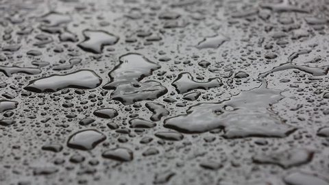 Rain drops close up seamless loop background. Rainy day weather. Loop able rain on water, raindrops. Water drops close up. Heavy rain falls. Seamless looping rain drops background.