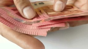 male hands of a businessman and trader counting ten euro banknotes, closeup. Holding and counting a stack of 10 banknotes in hands. close up video of a Person counting ten euro banknote money.