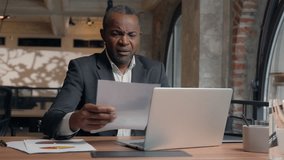Stressed upset failure paperwork stress problem troubled African American entrepreneur with laptop report check data in papers dissatisfied mistake bad result business man office businessman male guy - Powered by Shutterstock - Get 15% off with code: PIKWIZARD15