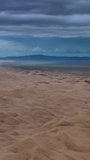 Aerial view on sand dunes with storm clouds at sunset in Gobi Desert, Mongolia. Vertical video
