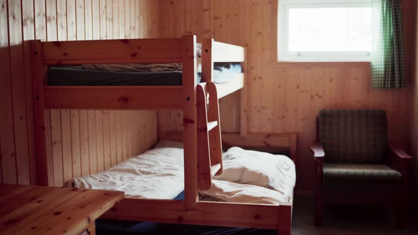 Interior Of A Wooden Cabin Bedroom With Double Bunk Beds. Handheld Shot