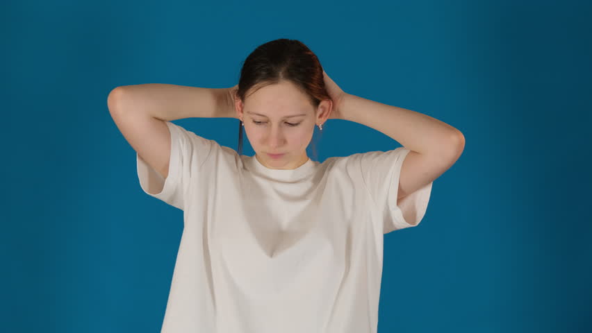 Disappointed lady lets hair down on blue background. Woman symbolically sheds weight of sadness embracing sense of liberation and vulnerability Royalty-Free Stock Footage #3481842821