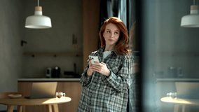 Happy excited young woman enjoy success on mobile phone at home standing by window on sunny day. Joyful redhead female reading good news on smartphone. Surprised lady celebrating victory on cellphone. - Powered by Shutterstock - Get 15% off with code: PIKWIZARD15