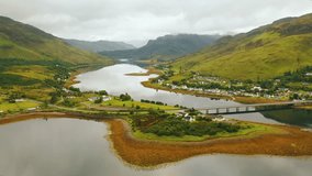 Drone shot of the Scottish Highlands. Aerial pan of small Scottish village Dornie on Loch Duich with mountains behind, Scotland, United Kingdom