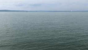 Video panorama of Lake Balaton (Hungary) with small waves against a blue sky with clouds