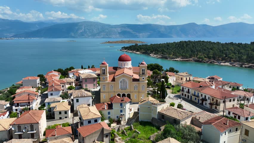 Aerial drone rotational video of picturesque fishing village of Galaxidi and landmark church of Agios Nikolaos, Fokida prefecture, Greece