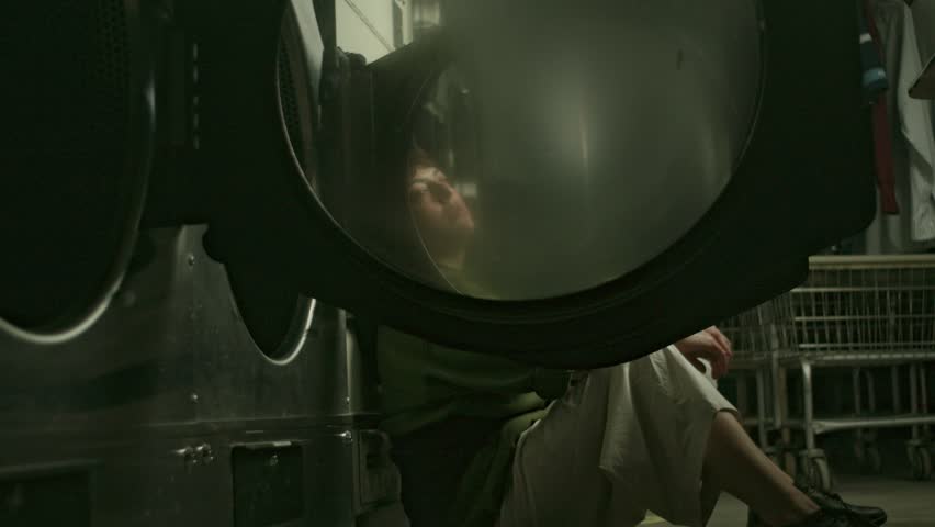 A Youg Latin Woman Having Solitary Reflections in the Laundry Room, Alone Sitting on The Floor