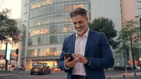 European latin middle age male entrepreneur businessman working on mobile cell phone. Confident mature hispanic senior business man holding smartphone cellphone, using app at busy street at evening - Powered by Shutterstock - Get 15% off with code: PIKWIZARD15