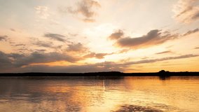 Sky and clouds at sunset over the lake shore. Beautiful, dramatic cloudy skyline in the red, orange and blue colors over the lake. Stock footage time lapse video 4k