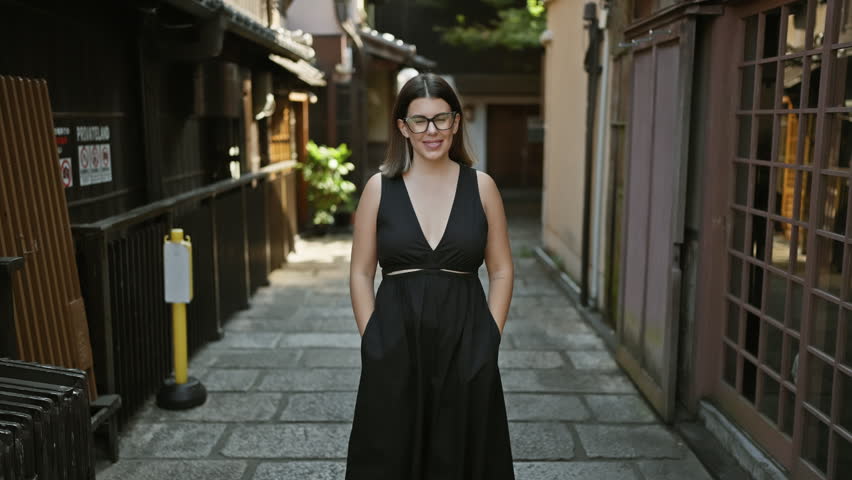 Unforgettable joy in kyoto, a confident, carefree, and beautiful hispanic woman wearing glasses, joyously strutting and smiling at the camera on a picturesque traditional japanese street.