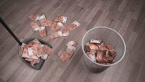 Throwing a heap of euro bills into a waste paper bin with a dustpan, wooden floor background. Finance, corruption, criminal activity concept. - Powered by Shutterstock - Get 15% off with code: PIKWIZARD15