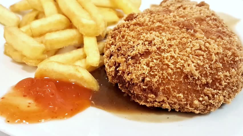 A close up view of the chicken cordon bleu, the french fries, and chili sauce on the white plate. Royalty-Free Stock Footage #3482203693