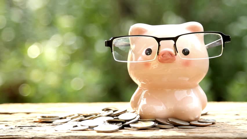 piggy bank business standing on a pile of coins conceptA hand is putting coin in a piggy bank on background saving money is an investment for future Royalty-Free Stock Footage #3482210035
