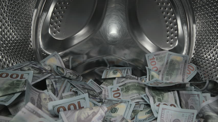 Washing a heap of one hundred dollar bills in washing machine, inside view of drum during spin cycle. Concept of money laundering, financial fraud.