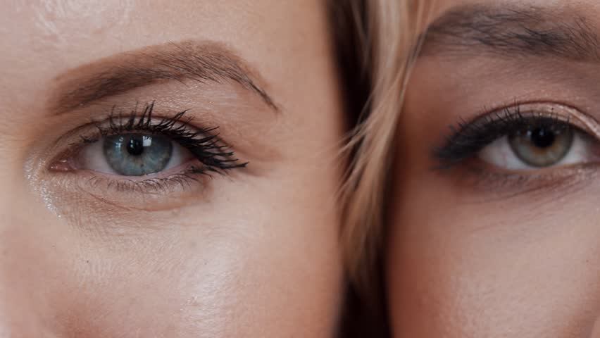 Close-up of a group of girls with different eye colors, leaning against each other. The girls have green and blue eyes. Extreme close-up. Slow motion. Royalty-Free Stock Footage #3482221069