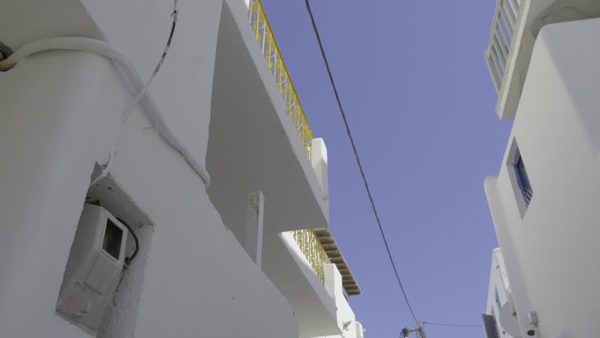 Pan down to a woman using her iPhone on vacation in Mykonos