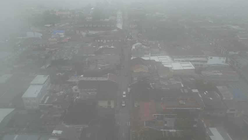 Aerial view of misty Parque Bolivar and the church Parroquia Inmaculada Concepción de Filandia in the Andean town of Filandia in the Quindío department of Colombia