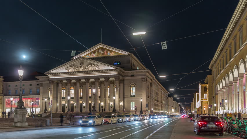 Munich National Theatre or Nationaltheater on the Max Joseph square night timelapse. Traffic on the street with trams and taxi parking. Historic opera house, home of the Bavarian State Opera. Germany Royalty-Free Stock Footage #3482566371
