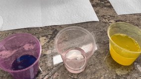 Mixing vinegar, food coloring, and water to dye Easter eggs.