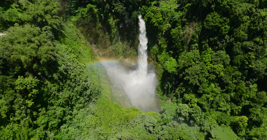 Beautiful Rainbow over Hikong Bente Waterfall surrounded by mountain jungle, rainforest and green trees. Lake Sebu. Mindanao, Philippines.
